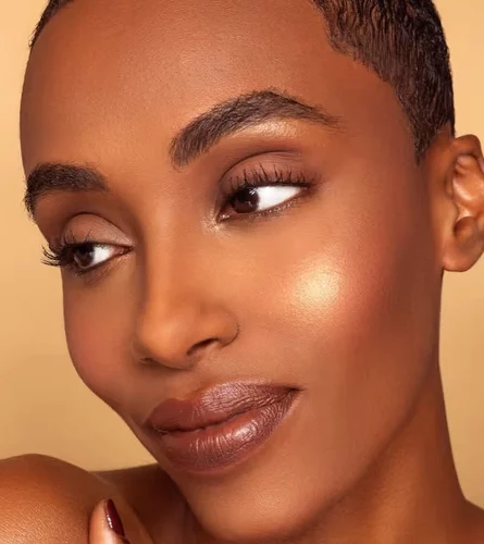 Woman with brown skin tone and glowing makeup