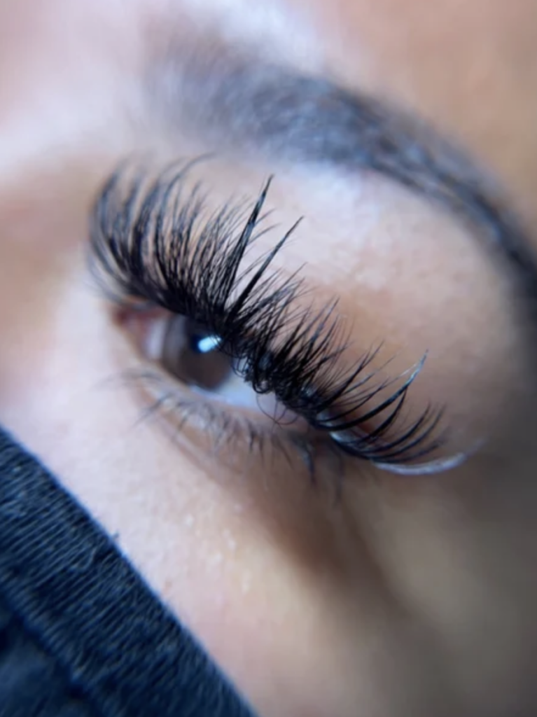 A woman's eye with a set of hybrid lash extensions 
