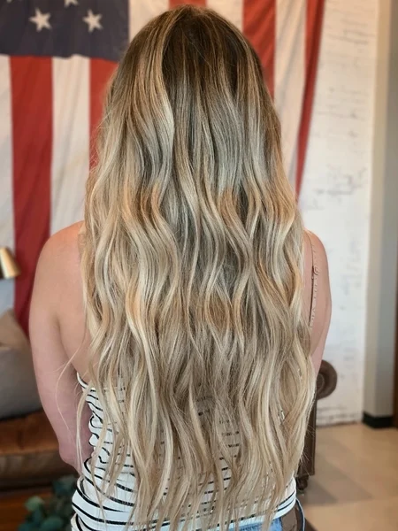 Long natural blonde hair with extensions and dimension.