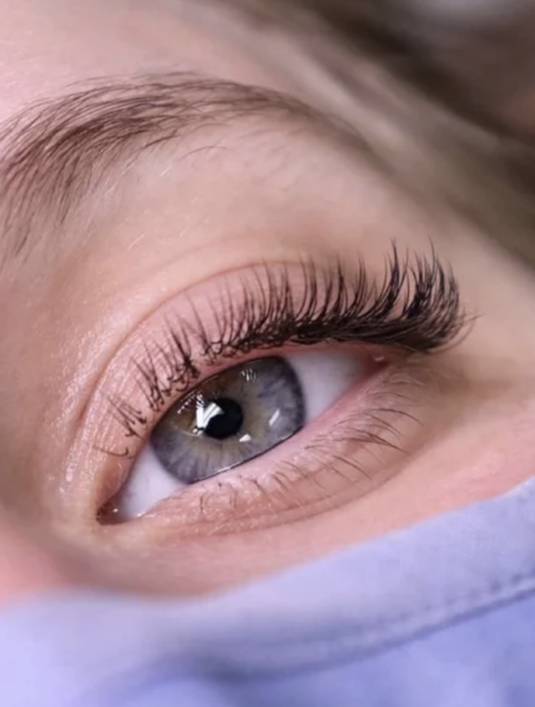 Close up image of an woman with blue eyes and natural eyelash extensions. 