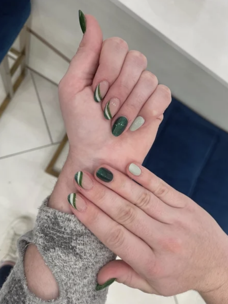 Light green and dark green nail art. Two nails have a green stripe french tip. 