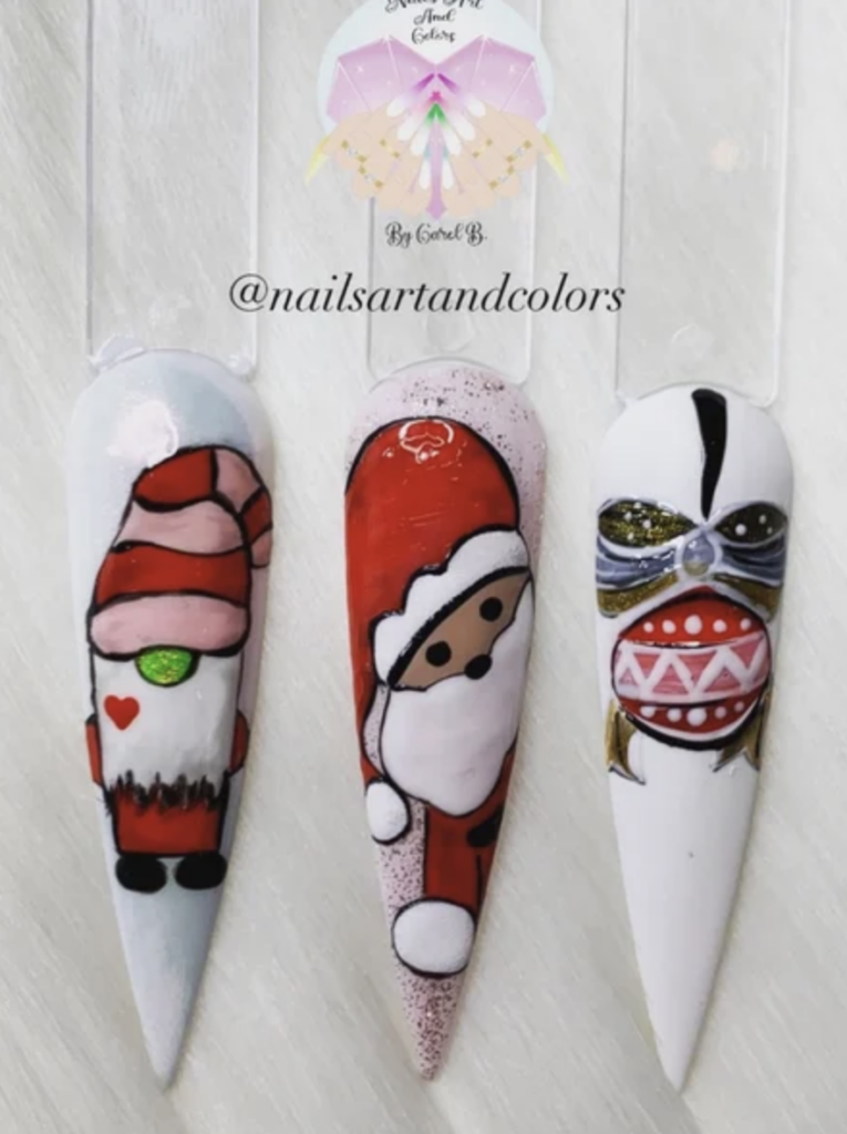 Three press on nails with two decals of cartoon santas and an ornament. 