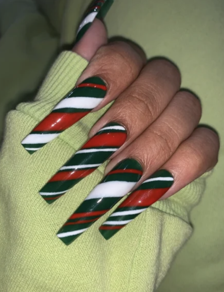 Very long square tip nails with emerald, red and white diagonal candy cane stripes. 