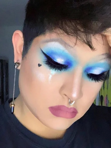 Shades of blue eyeshadow blended up to the eyebrow completed with a long and sharp winged eyeliner. 