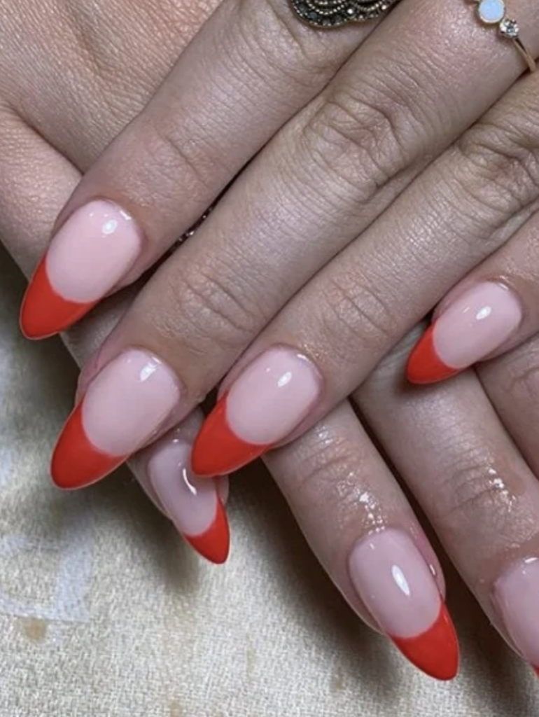 Long, almond shaped nails with red french tips. 