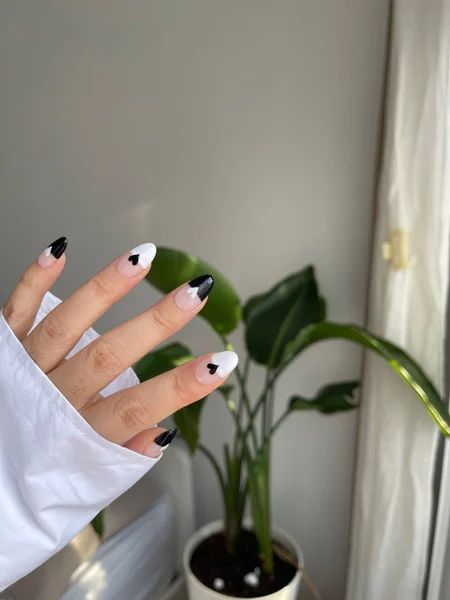 Black and White alternating nails with a heart decal of the opposite color in the middle of each nail. 