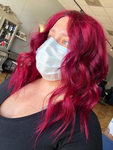 Woman with magenta hair styled with a curling iron.  