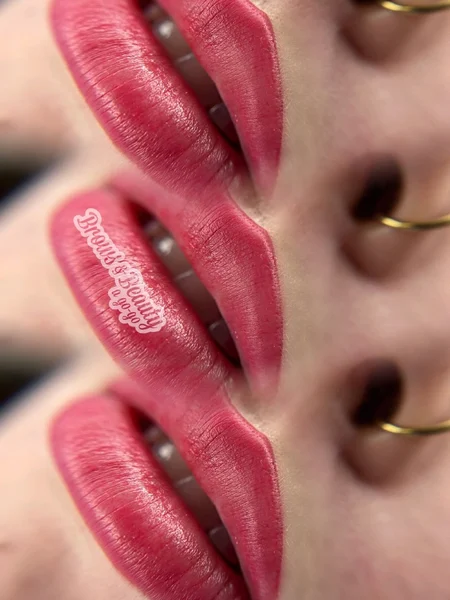 Woman's lips with permanent, blush pink lipstick tattooed. 
