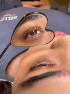Hybrid lash extensions shown in a heart shaped mirror. 
