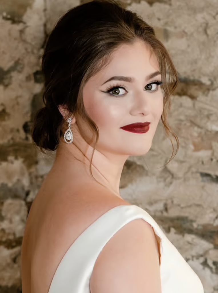 A woman with fair skin in bridal makeup with a hollywood dark red lip for the perfect oscars hair and makeup look.