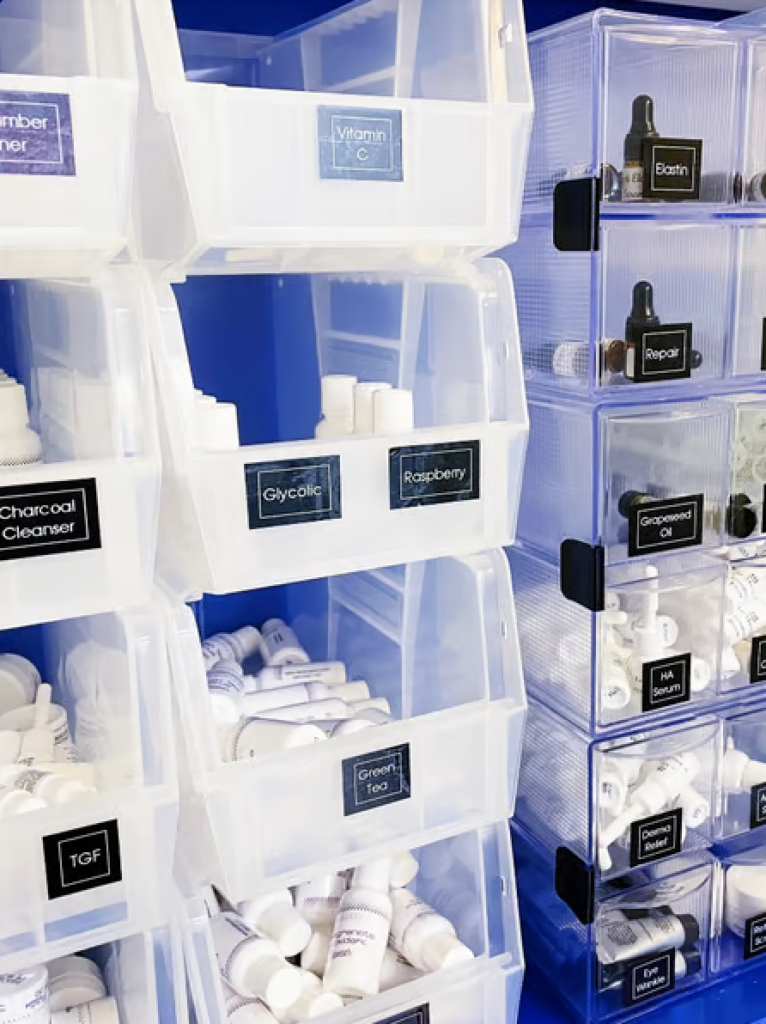 Chemical products organized in plastic bins with black labels. 