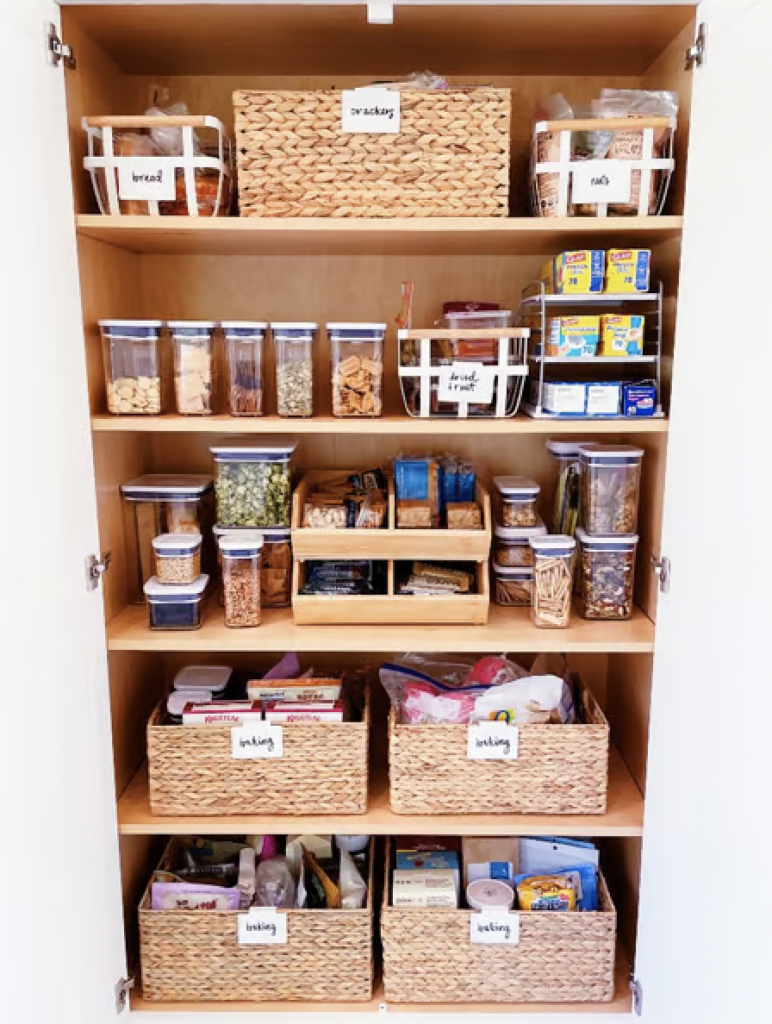 A pantry with food woven bins and empties into clear OXO food storage containers. 