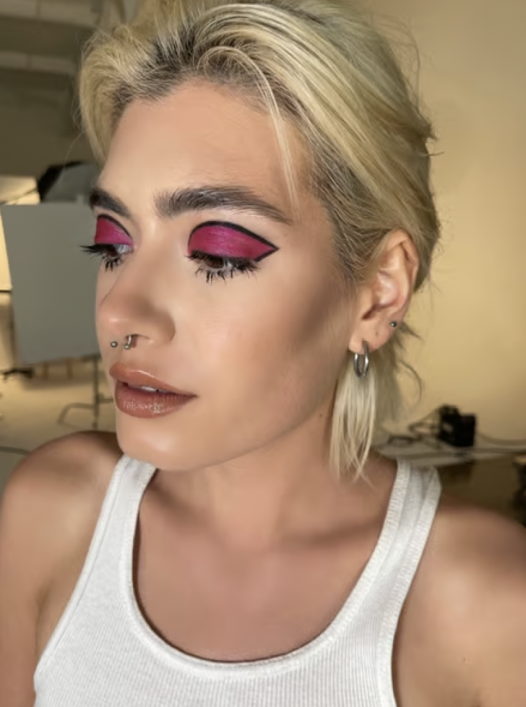 Bold, hot pink eyeshadow outlined with a black liner. 