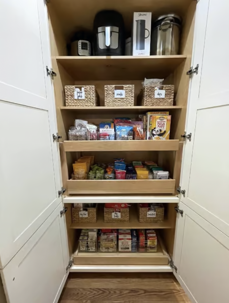 A pantry organized with bins and items sorted in drawers. 