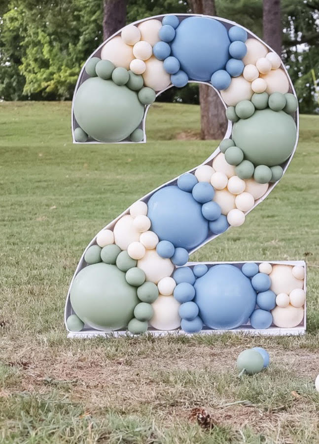 A 5ft tall #2 balloon mosaic filled with sage, light blue, and white balloons. 