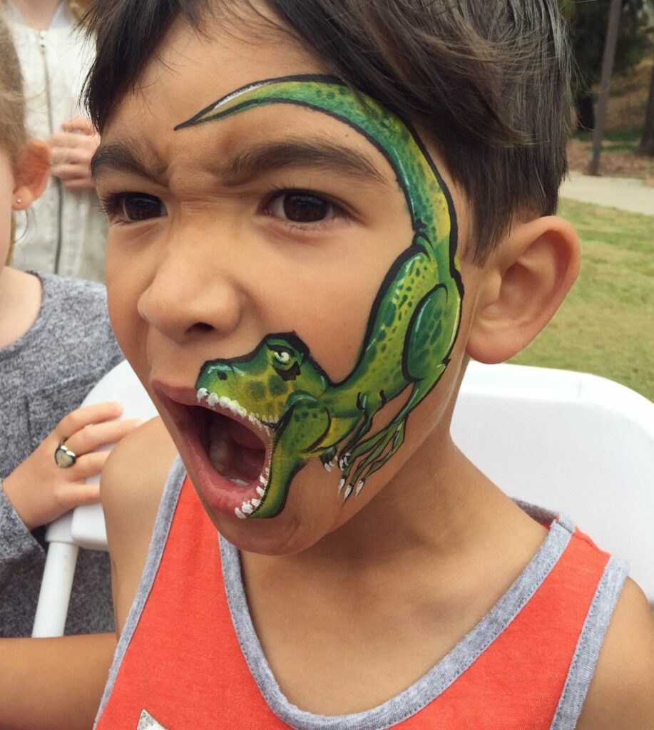 A full dinosaur painted on the side of kid's face. 