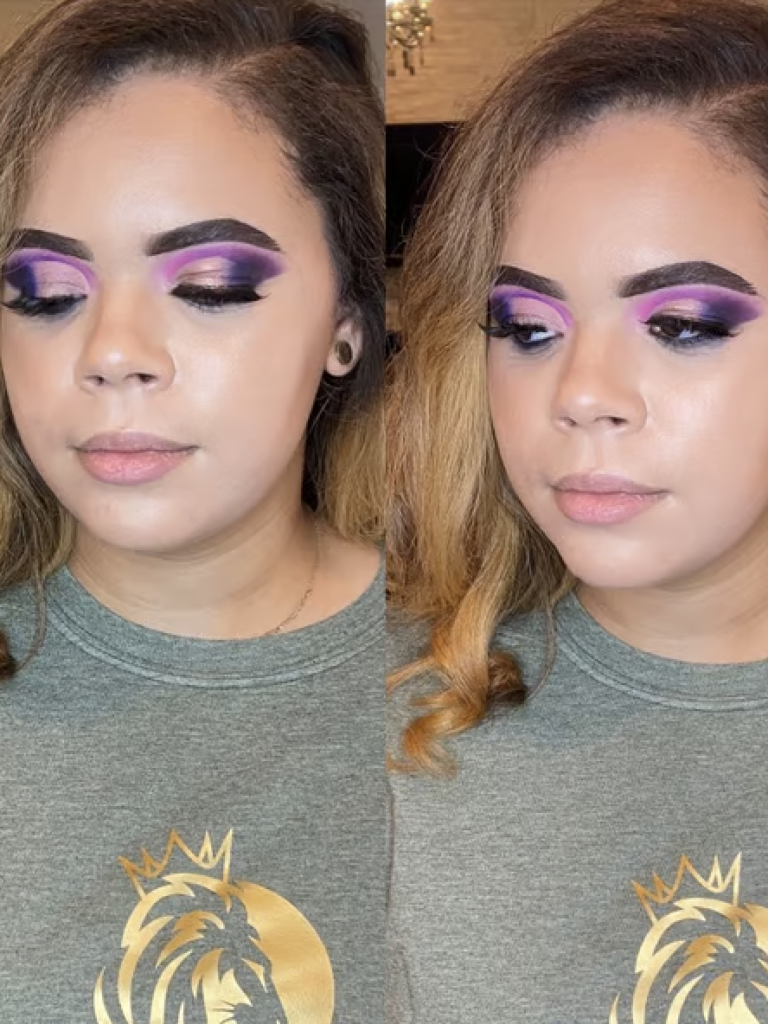A woman with a bold eyeshadow look consisting of purple, white, black and grey colors. 