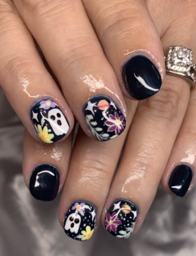 Black short nails with ghost, floral, and sparkledesigns. 