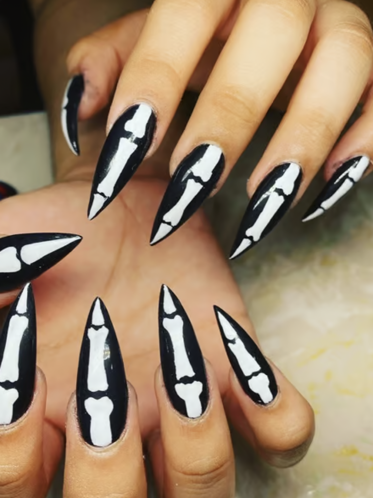 Long black pointed nails with white skeleton bone decals. 