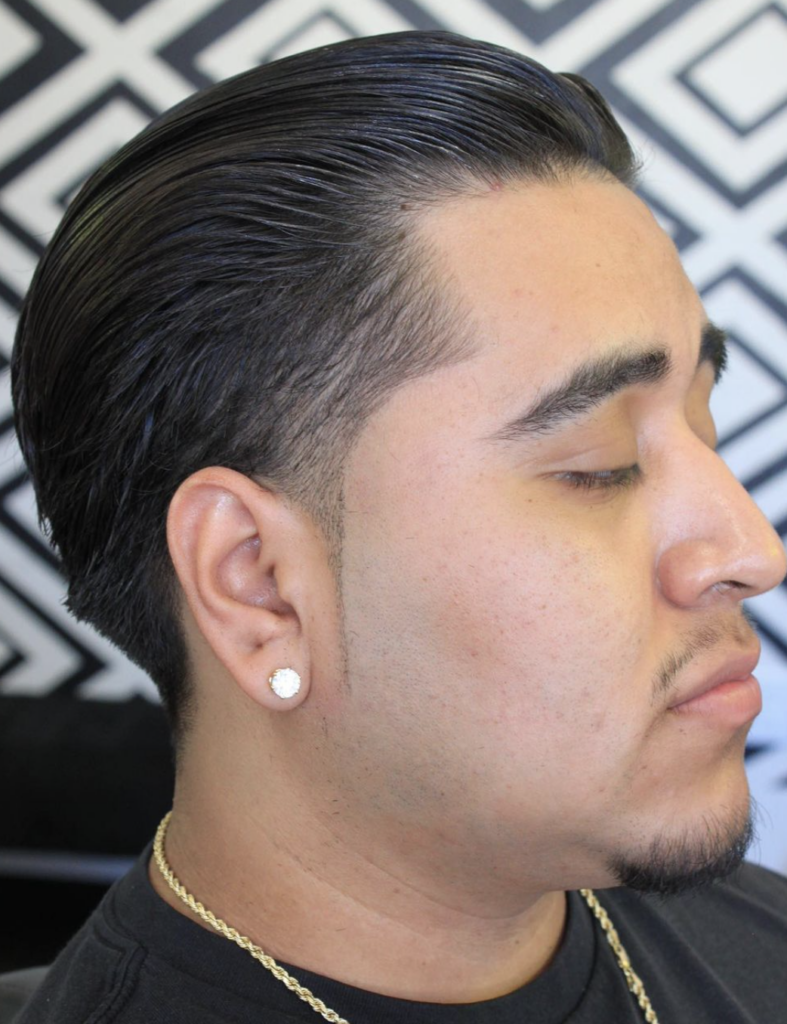 Man with fresh haircut with slicked back hair. 