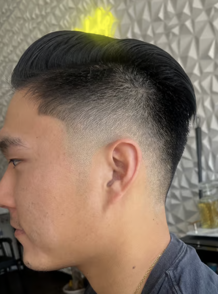Man with a fresh haircut with short sides and a long top. 